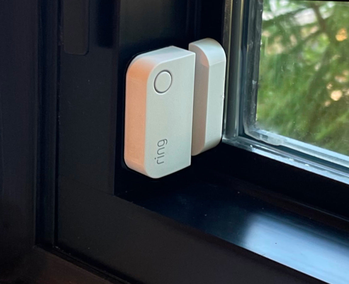 White ring sensor installed on black modern window